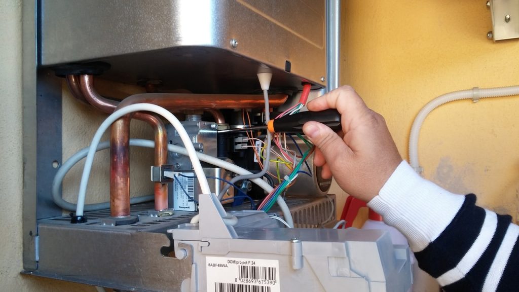 A picture of a man fixing electric boiler problems